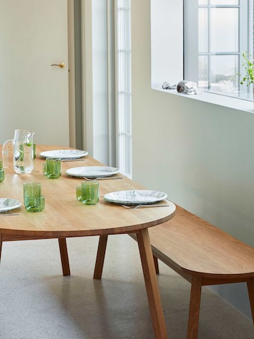 A wood Triangle Leg Table with a Triangle Leg Bench, set for a meal.