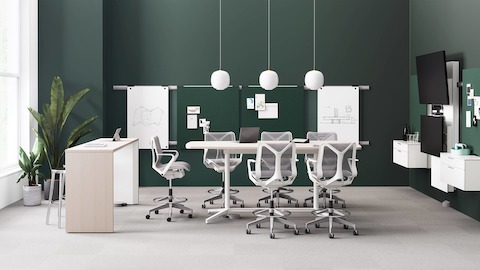 A Headway Communal Table and Y-base Headway Conference Table in a work environment with Cosm Stools, Logic Reach power, and Exclave collaborative furniture.