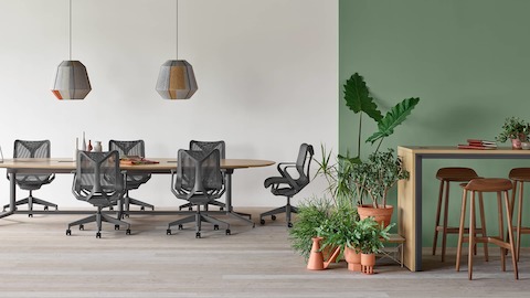 A Y-base Headway Conference Table surrounded by Cosm chairs and a Headway Communal Table with Crosshatch Stools in an open conference space.