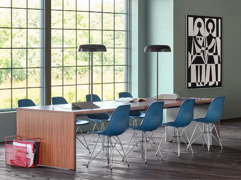 A community space with a Headway Communal Table surrounded by Eames plastic side chairs.