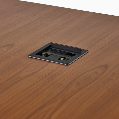 A close-up view of a Crestron unit in the surface of a Headway conference table.