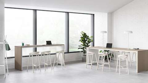 An office setting with two Headway communal tables, one counter height and the other standing height.