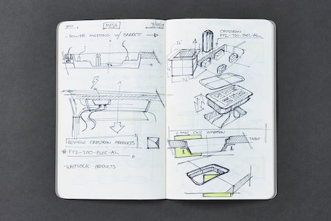 Primer plano de una computadora portátil que contiene bosquejos de prototipos para el diseño de la mesa de conferencias Headway.