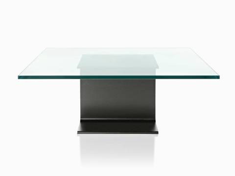 Una mesa auxiliar eam de aluminio fundido con una tapa de cristal.