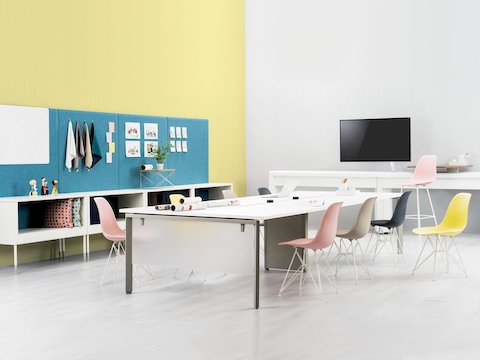 Imagine Desking System surrounded by a variety of colourful Eames shell chairs. Public Office Landscape storage solutions in the background.