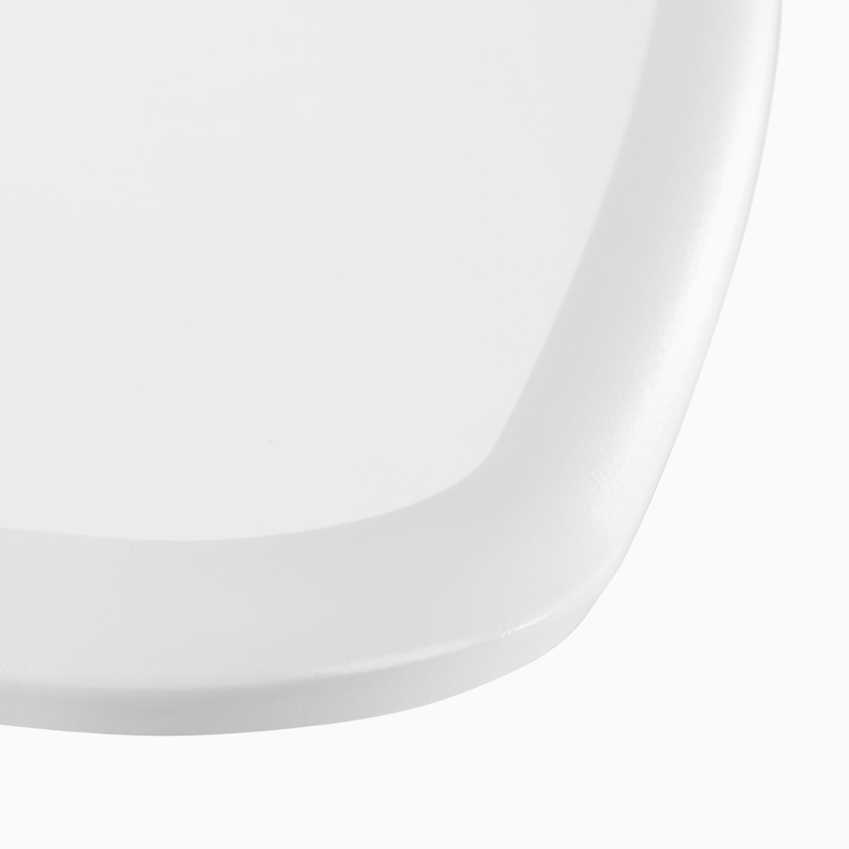 A close-up view of the surface edge of an Intent Solution's mobile table in a white laminate finish.