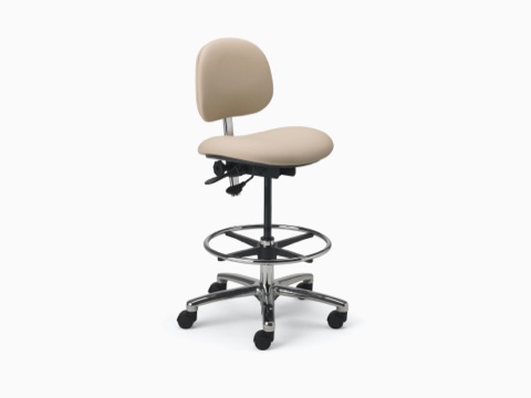 Lab Stool in a beige upholstered seat and back and a chrome base with dual lever adjustment, footrest, and a 5-star base with casters.