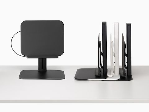 从正面看黑色的 Lana 笔记本电脑支架，从侧面看一堆黑色和白色的 Lana 笔记本电脑支架。