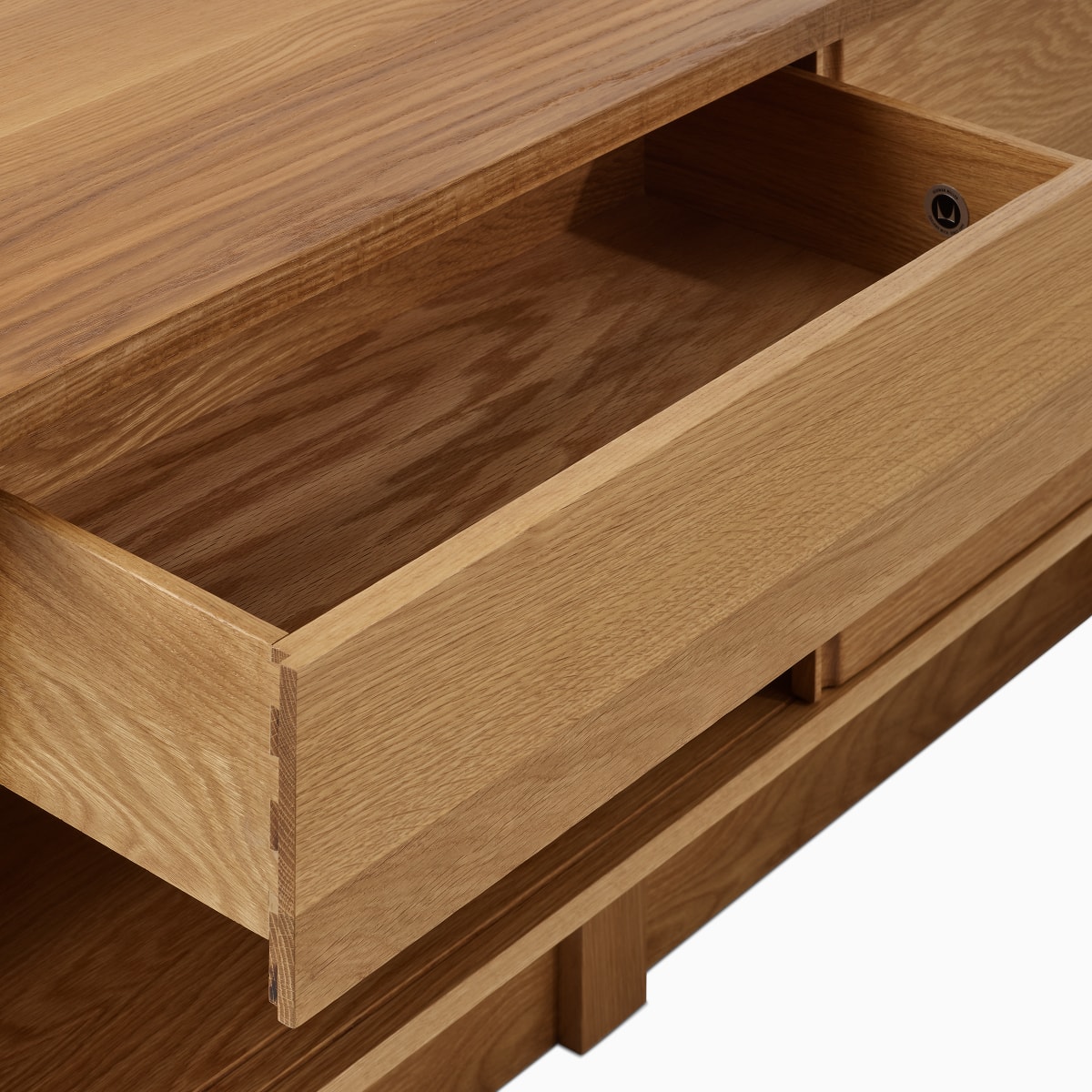 A detail view of the Land Storage drawer in oak with Herman Miller logo bug.