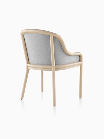 Vue de trois quarts arrière d'une chaise Landmark avec la tapisserie d'ameublement gris-clair et un cadre en bois léger.