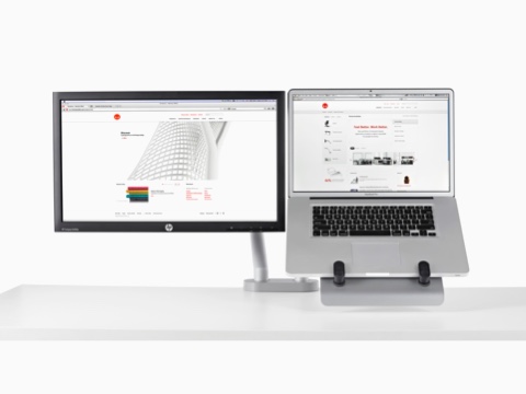 A dual monitor arm supports both a computer screen and a Laptop Mount that holds a notebook computer.