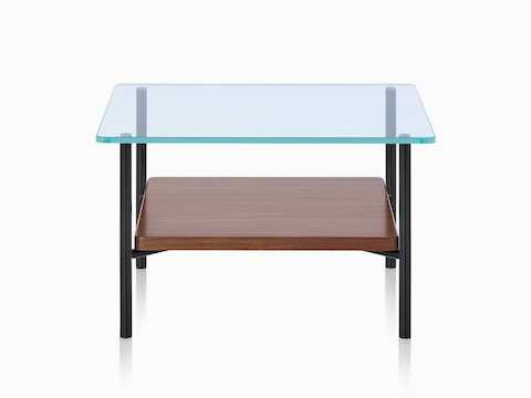 Een Layer bijzettafel met glazen blad met een donker houten onderste schap. Een Layer bijzettafel met glazen blad met een donker houten onderste schap.