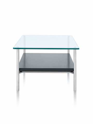 Un tavolo per uso occasionale Layer rettangolare con piano in vetro e ripiano in pietra, visto dall’estremità più stretta.