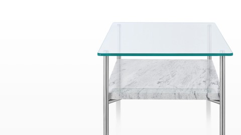 Uma mesa com tampo de vidro Layer com uma prateleira inferior de pedra.