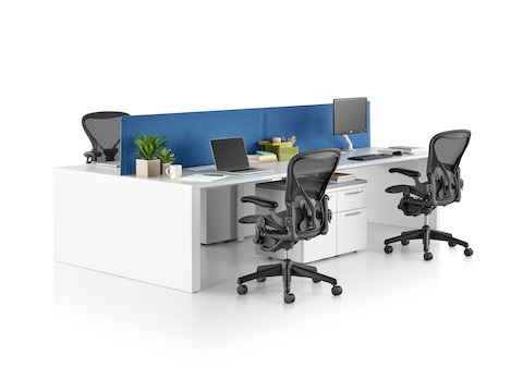 A Layout Studio bench with a white laminate top, blue tapered-edge fabric center privacy screens, gallery panel, four Aeron Chairs, and Tu pedestals.