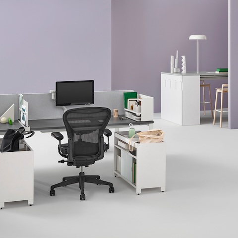 An office setting with two Layout Studio benches with gray fabric center privacy screens, Ubi Work Tools, Tu credenzas, and Aeron and Setu Chairs. An office setting with two Layout Studio benches with gray fabric center privacy screens, Ubi Work Tools, Tu credenzas, and Aeron and Setu Chairs.