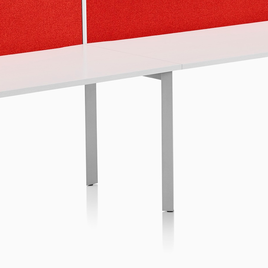 Viewed at an angle, a single-sided Layout Studio bench for two with a white top, gray base, and a red, framed fabric, surface-attached screen.