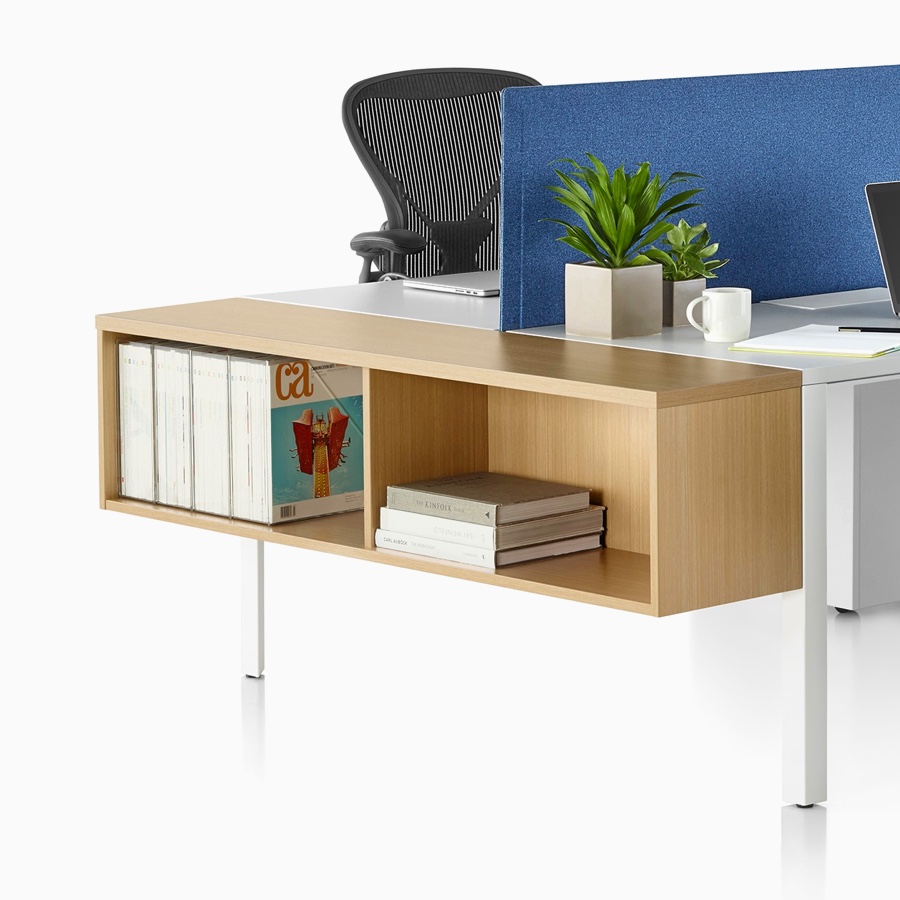 Layout Studio bench with a white top and base, privacy screens, four Aeron chairs, Tu Wood Pedestals, and Tu wood suspended cubby at the end of run.