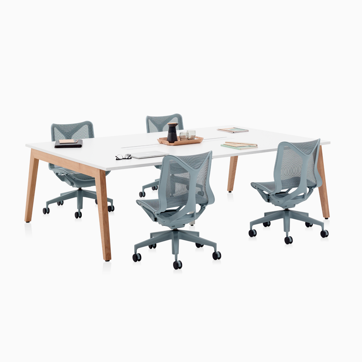 Layout Studio Sitzungstisch mit Stromversorgung und Holzbeinen sowie vier Cosm Stühlen in Grau mit niedrigem Rücken.