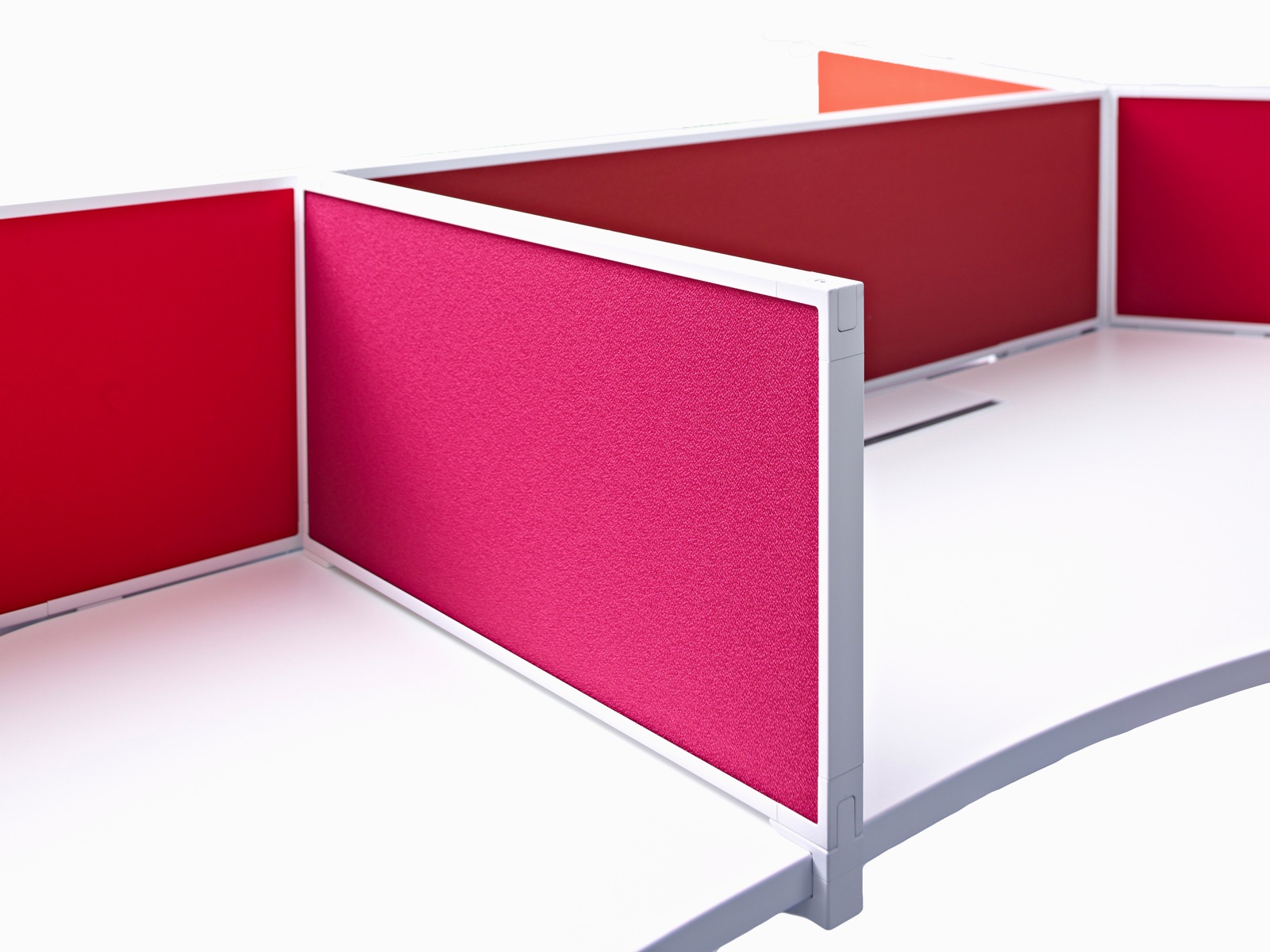 Close-up of the framed red fabric, delineation privacy screen that's placed on top of a work surface to divide desk space.