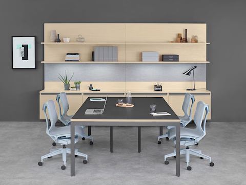 Sitzungsraum-Umgebung mit Layout Workwall hinter einem Layout Studio-Sitzungstisch mit hellgrauen Cosm-Stühlen.