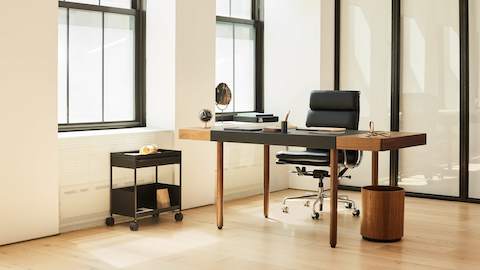 A corporate office setting with the Leatherwrap Sit-to-Stand Desk and Eames Soft Pad chair.