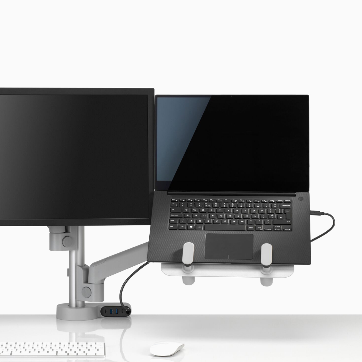 Visão frontal de um braço para monitor Lima em uma configuração dupla integrada a um suporte para laptop Lima e um módulo de conectividade Ondo.