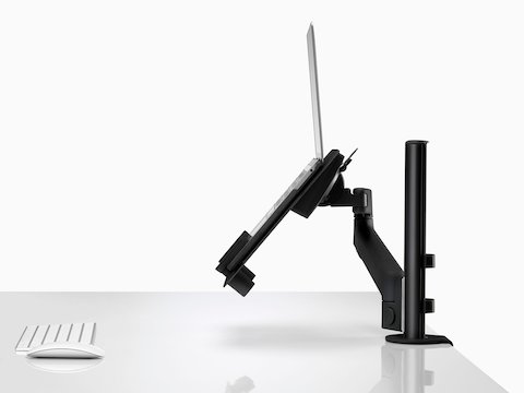 Vista de perfil de um laptop aberto e elevado, apoiado por um suporte para laptop Lima conectado a um braço para monitor Lima.