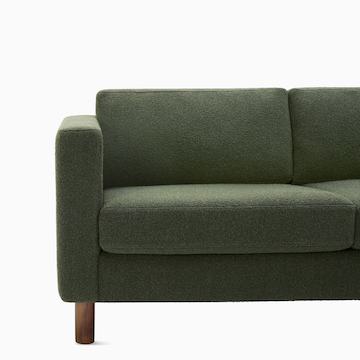 Detail view of three seater Lispenard Sofa, 17 inches in dark green textile and 6 inch walnut legs.