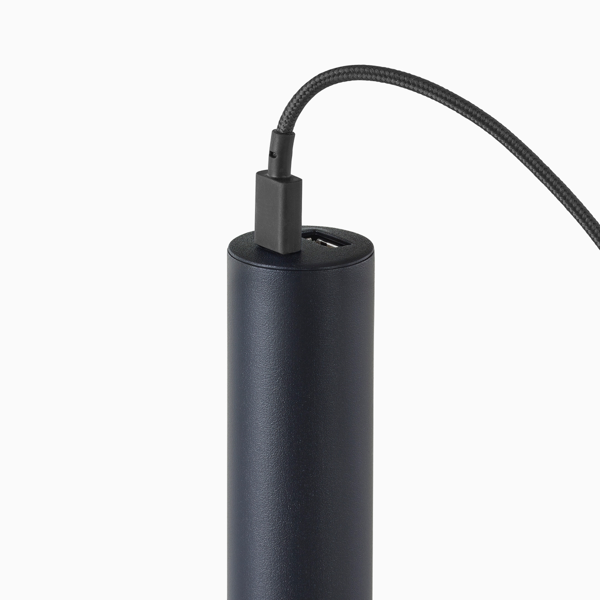 Primer plano de una micro torre Logic en negro con un cable conectado a un puerto USB-C.