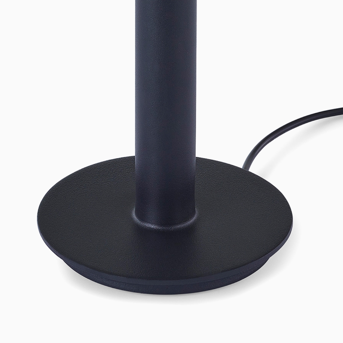 A close-up view a black Logic Micro Tower's base with its power cord partially wrapped around it.