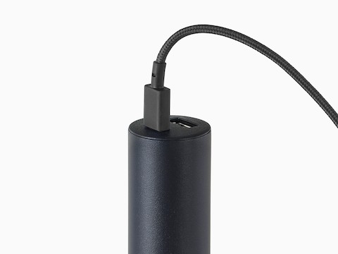 A close-up view of a black Logic Micro Tower with a cord plugged into the USB-C port.