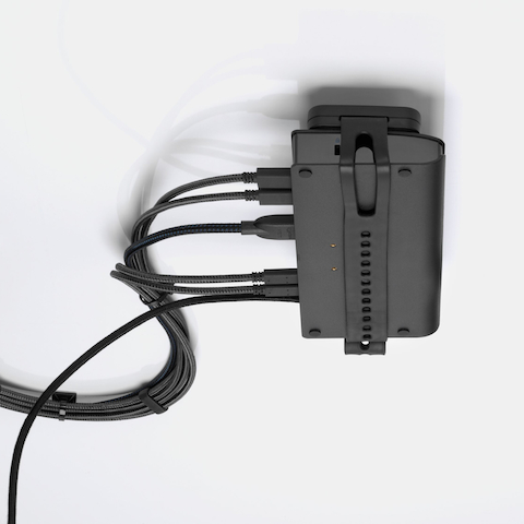 Loop Micro Mount attached under a desk cradling a thin client or power docking station with attached cables that are routed tidily to the edge and above the desk.