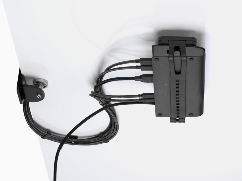 Loop Micro Mount bevestigd onder een bureau met daarop een dun client of power docking station met bevestigde kabels die netjes naar de rand en boven het bureau geleid zijn. Loop Micro Mount bevestigd onder een bureau met daarop een dun client of power docking station met bevestigde kabels die netjes naar de rand en boven het bureau geleid zijn.