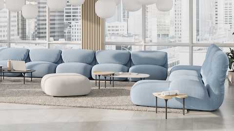 Sofá modular Luva e mesas Cyclade em ambiente de lounge comercial.