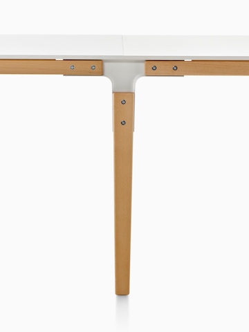 Close view of the construction of a Magis Steelwood Table, focusing on the steel joint between the wood legs and crosspieces.