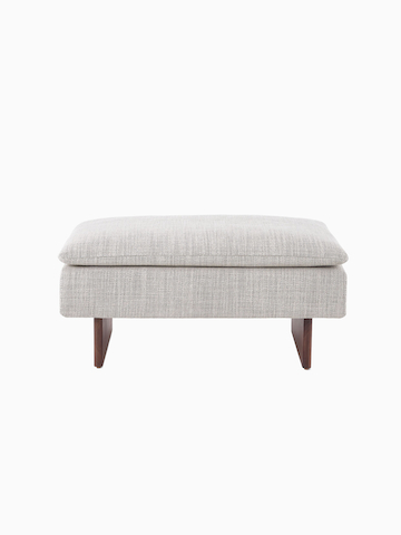 A Mantle Ottoman upholstered in Capri Stone with a Walnut Wood Base.