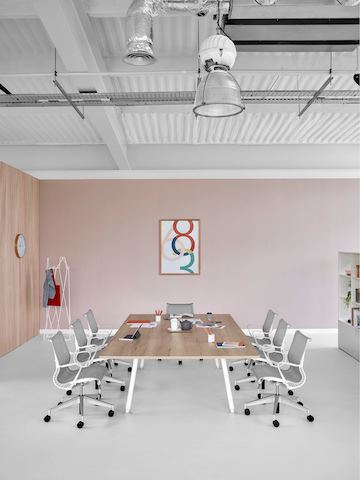 Une table de réunion rectangulaire Memo entourée de chaises de bureau Setu gris clair.