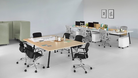 An open work area featuring a Memo meeting table and six Memo benching surfaces with light grey Aeron office chairs.