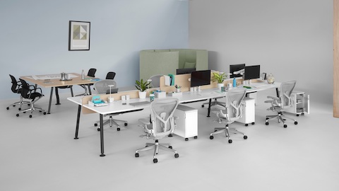 Ein offener Arbeitsbereich mit einem Memo-Besprechungstisch und sechs Memo-Sitzflächen mit hellgrauen Aeron-Bürostühlen.