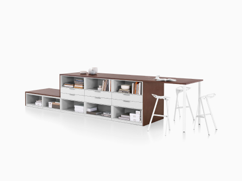 Archivo lateral de almacenamiento Meridian en marrón oscuro y blanco y configuración de biblioteca con superficie colaborativa y tres taburetes Magis Stool One en blanco. Archivo lateral de almacenamiento Meridian en marrón oscuro y blanco y configuración de biblioteca con superficie colaborativa y tres taburetes Magis Stool One en blanco.