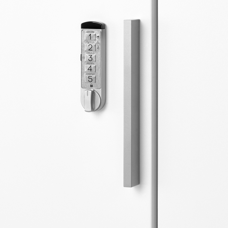 Imagem aproximada de uma fechadura sem chave e um puxador em barra prateados em um armário Meridian branco.