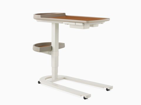 Angled view of Mirage Overbed Table with laminate top and tray with urethane edge with a U-base in a light gray finish.