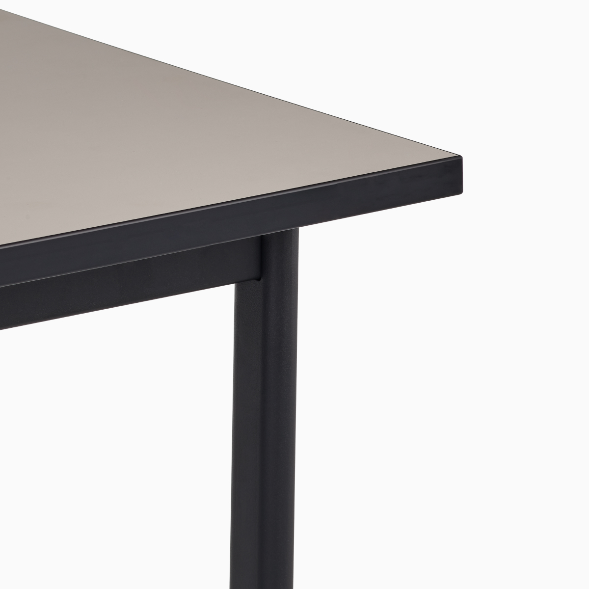 Detail view of the sandstone laminate top on a black Mode desk.