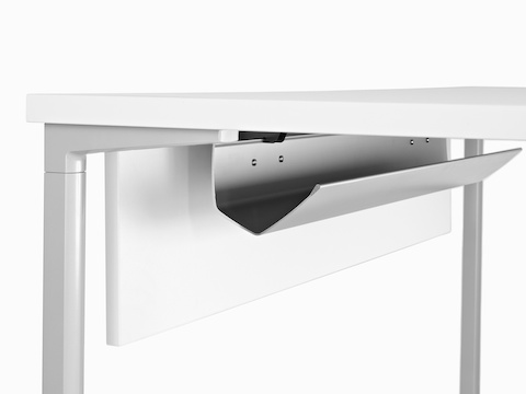 A white work surface equipped with a Modesty Panel and cable management trough. A white work surface equipped with a Modesty Panel and cable management trough.