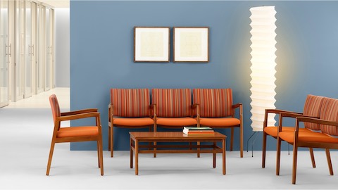 A healthcare waiting area including three-seat and two-seat Monarch Multiple Seating with orange upholstery and intervening arms.
