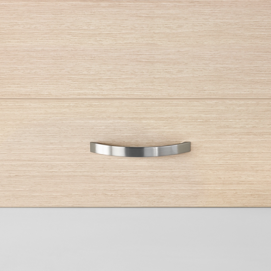 A close-up view of a Mora System casework arc drawer pull in a silver finish on storage in an ash wood finish.