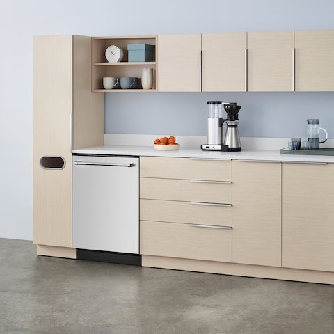 A staff lounge setting with Mora Casework in an ash finish with a storage tower, upper and lower storage, and a white sink and integrated backsplash.