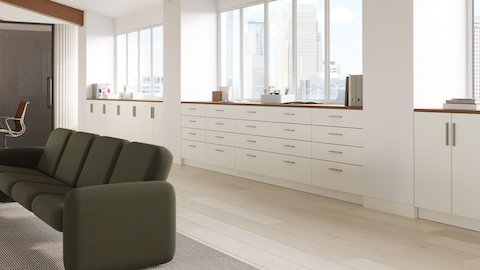 Mora Casework storage in a workplace setting in white finishes and walnut top.