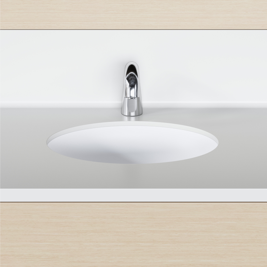 A close-up view of a Mora Casework integrated sink and backsplash in white solid surface.